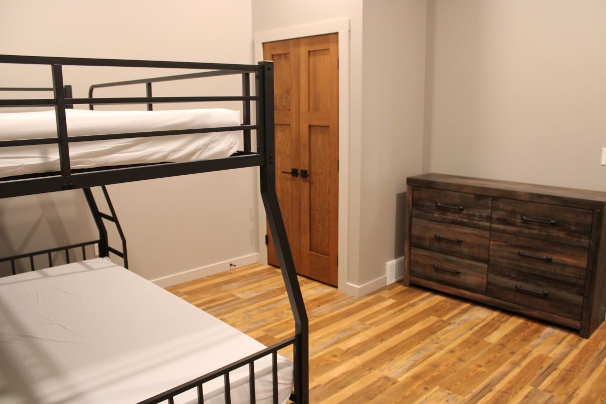Bunk bedroom in basement with dresser and closet