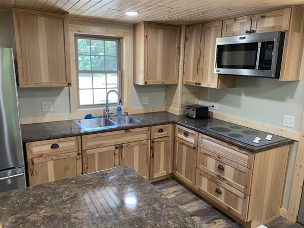 Kitchen area. View of kitchen area in cabin, including cook top, microwave and fridge.