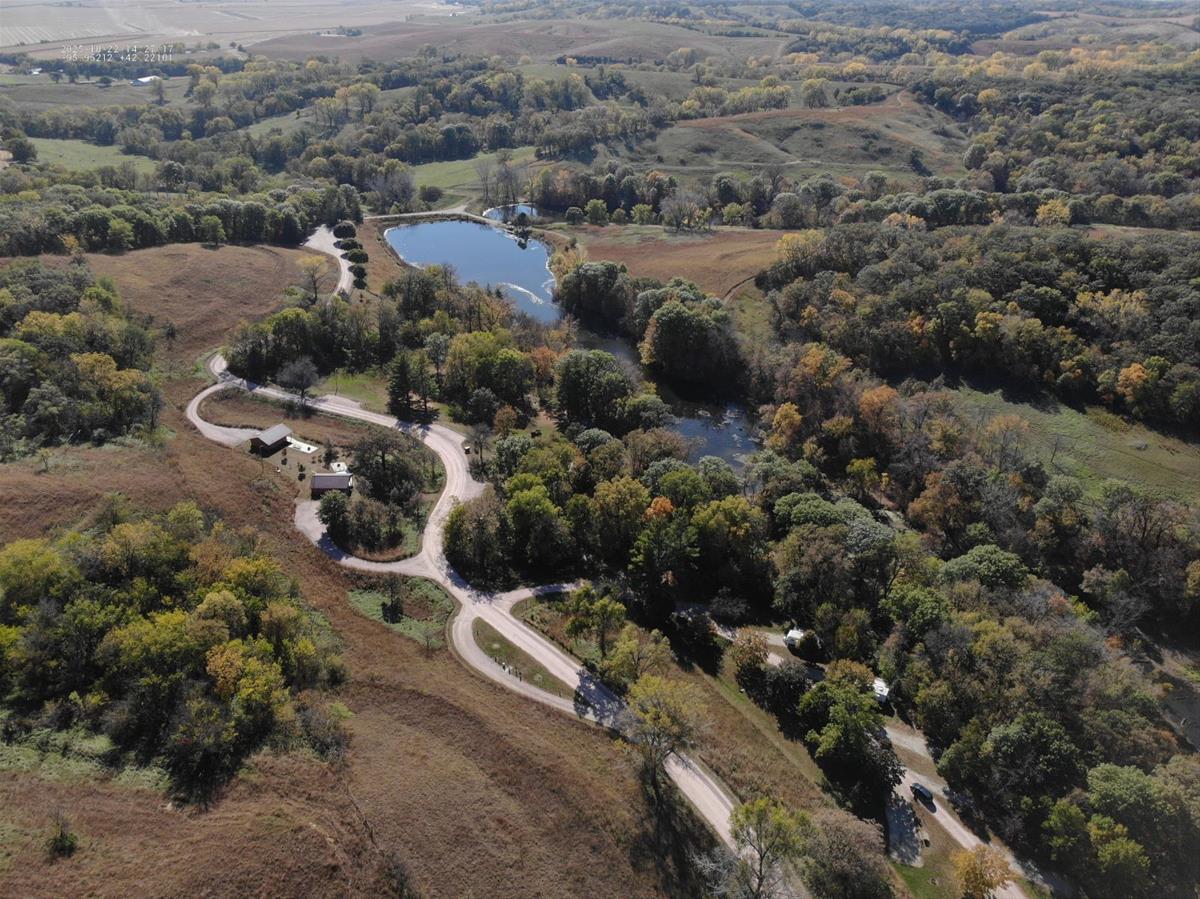 Aerial view of Southwood with campsites, dense trees, open grassy hills, and two connected ponds.
