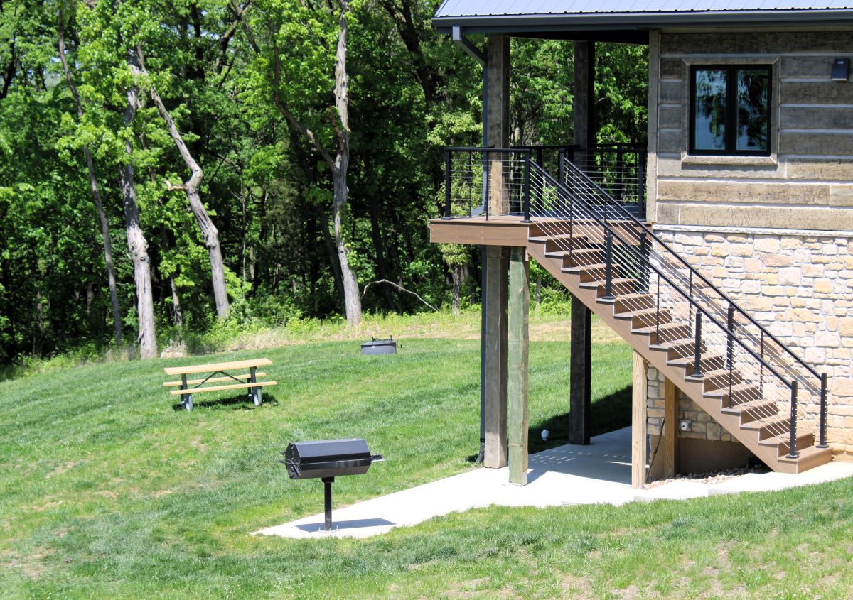 Grill, firepit, and picnic table area near lower level patio 