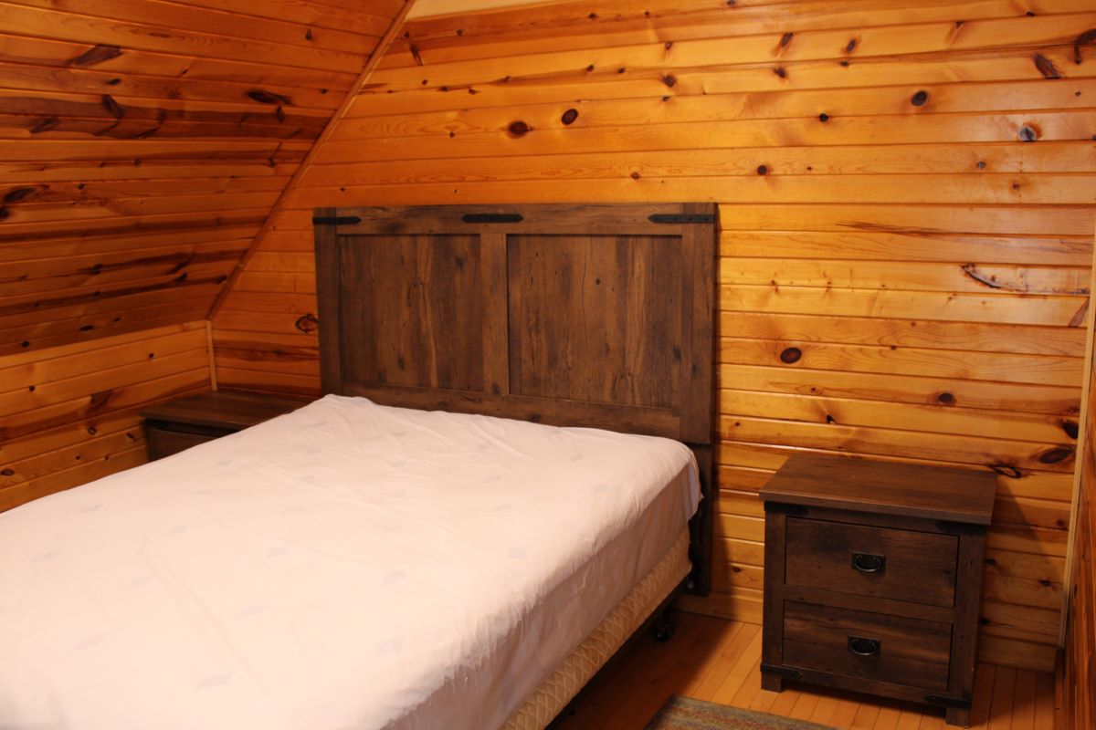 Upstairs queen bedroom with 2 nightstands and a dresser, queen bed in the center of the loft area