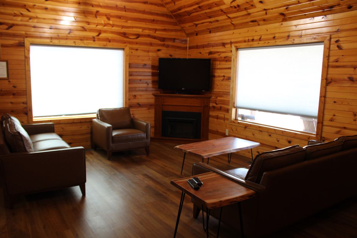 Living room with 2 sofas, a chair, 2 coffee tables, a side table, 2 picture windows, a flat screen T