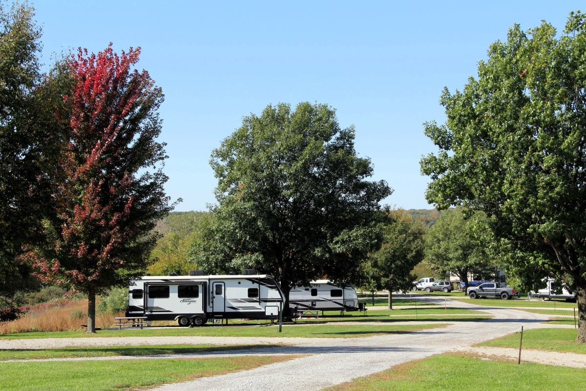 Campers along a gravel lane with fall foliage 