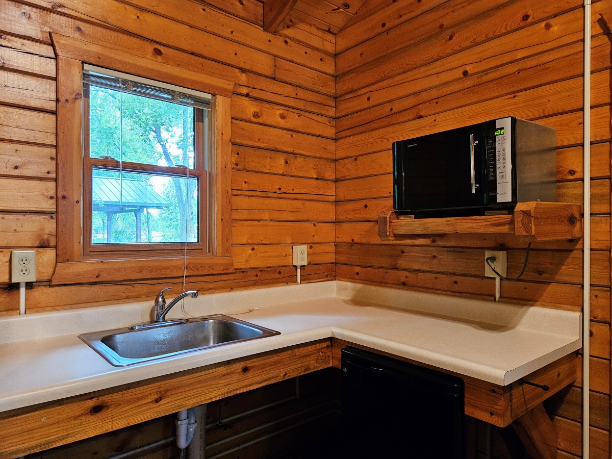 Prairie Rose - Cabin interior showing kitchen area with sink, microwave & mini-fridge