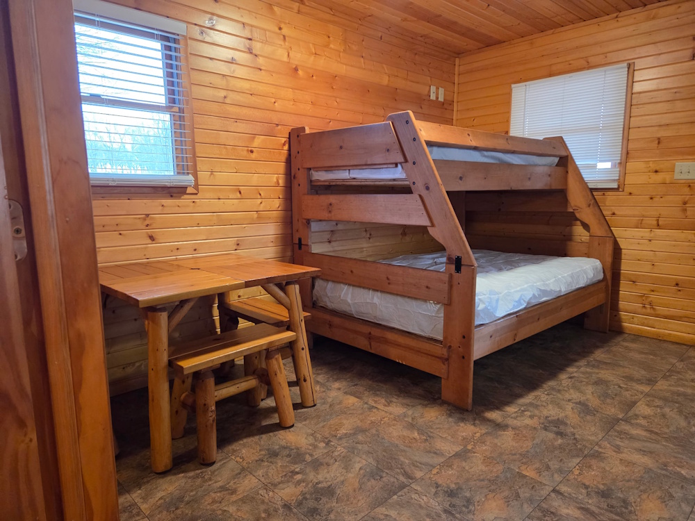 Foxes Den- main living space with bunkbed and small table.