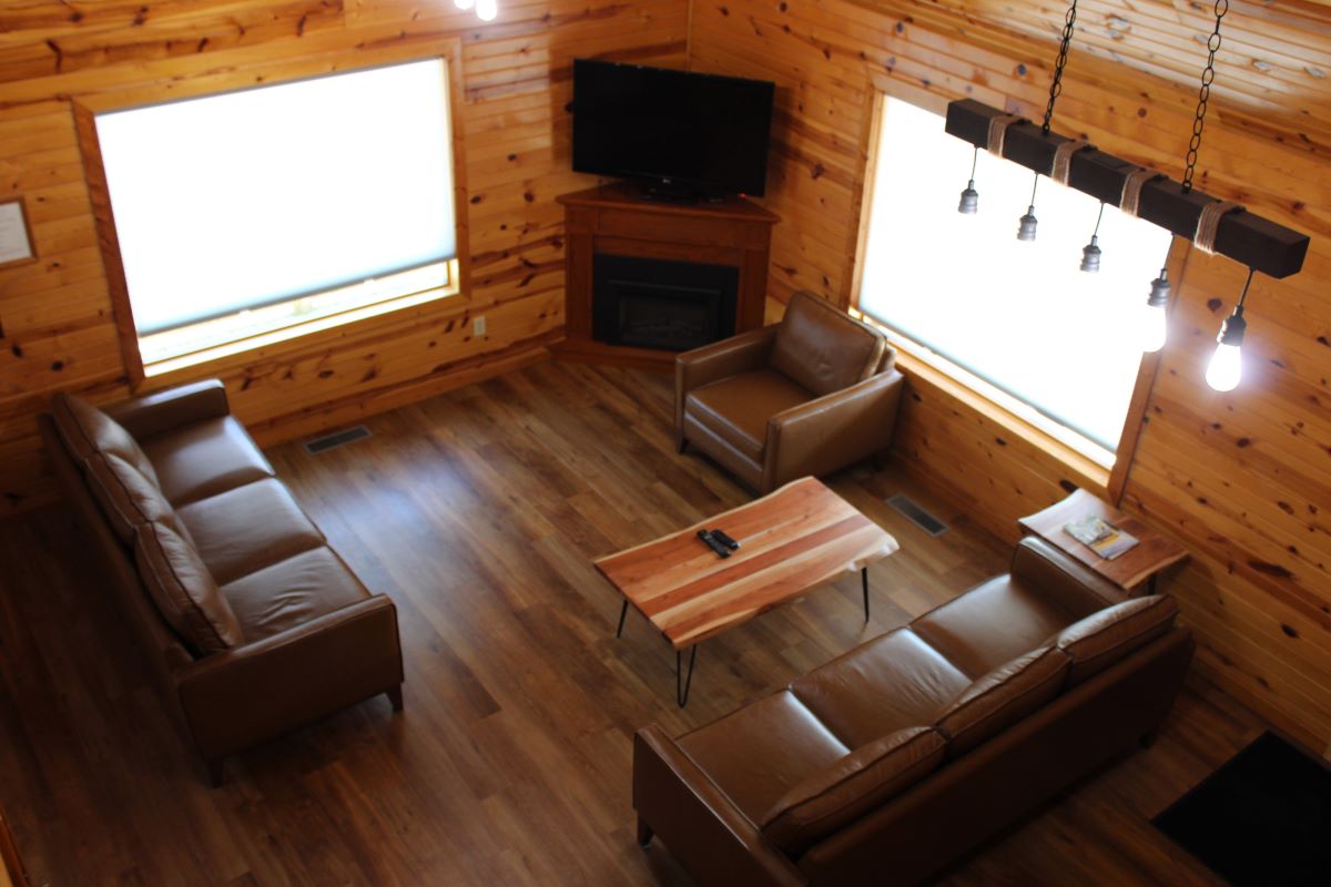 Living room with 2 sofas, a chair, 2 coffee tables, a side table, 2 picture windows, a flat screen T