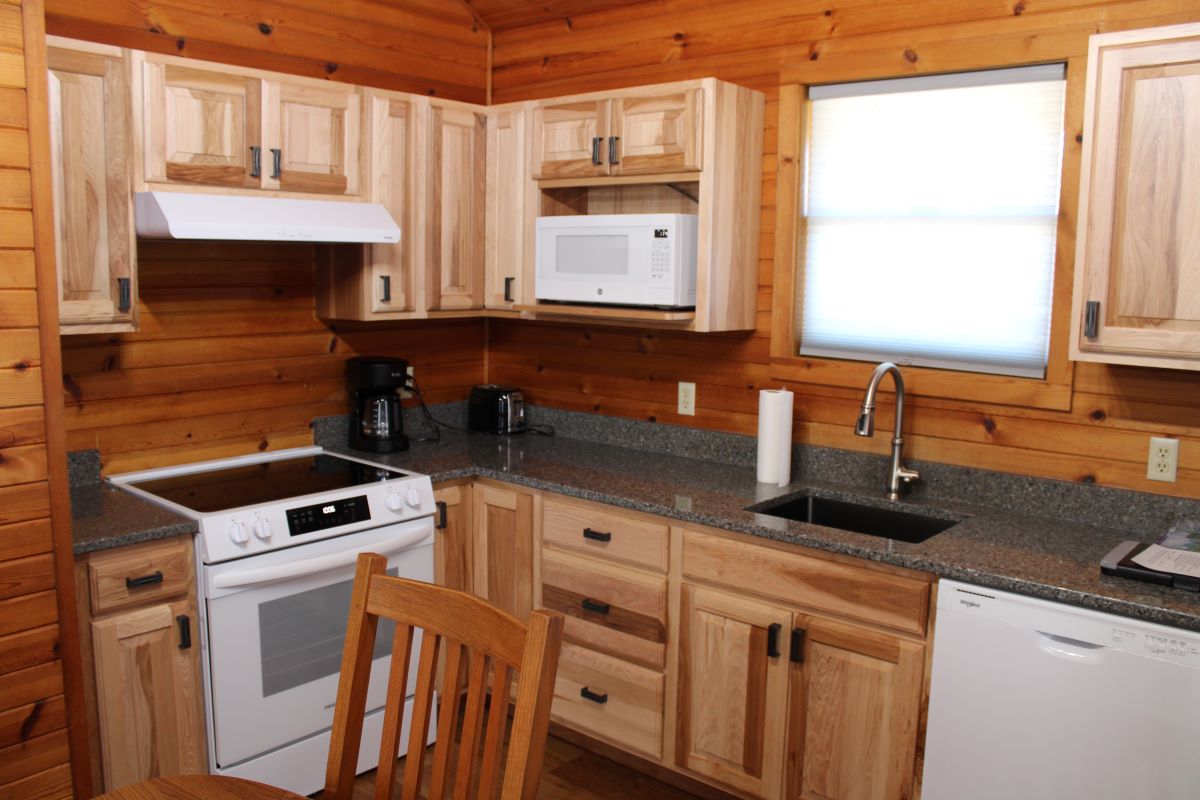 Kitchen cabinets and appliances in a log style cabin setting
