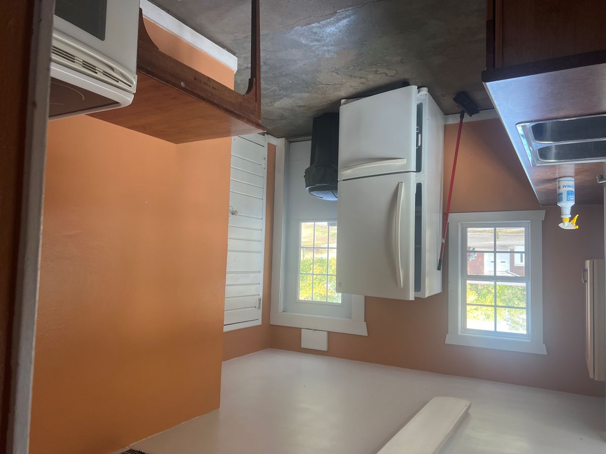 Kitchen area with fridge, sink, stove and prep space