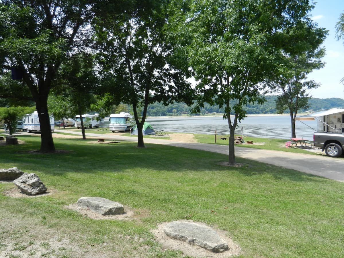 A couple empty gravel campsites along the lake. 