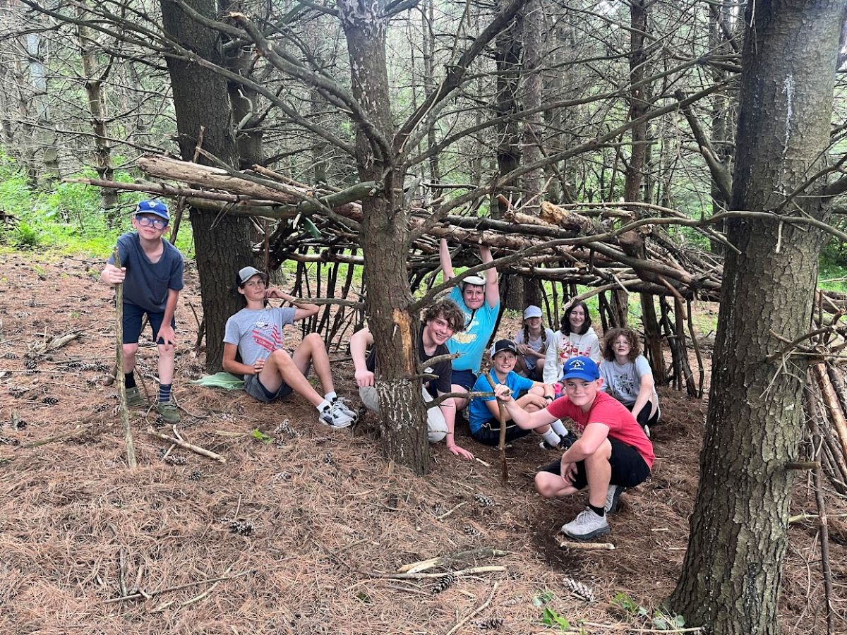 Summer campers build shelters in the woods at Lake Meyer