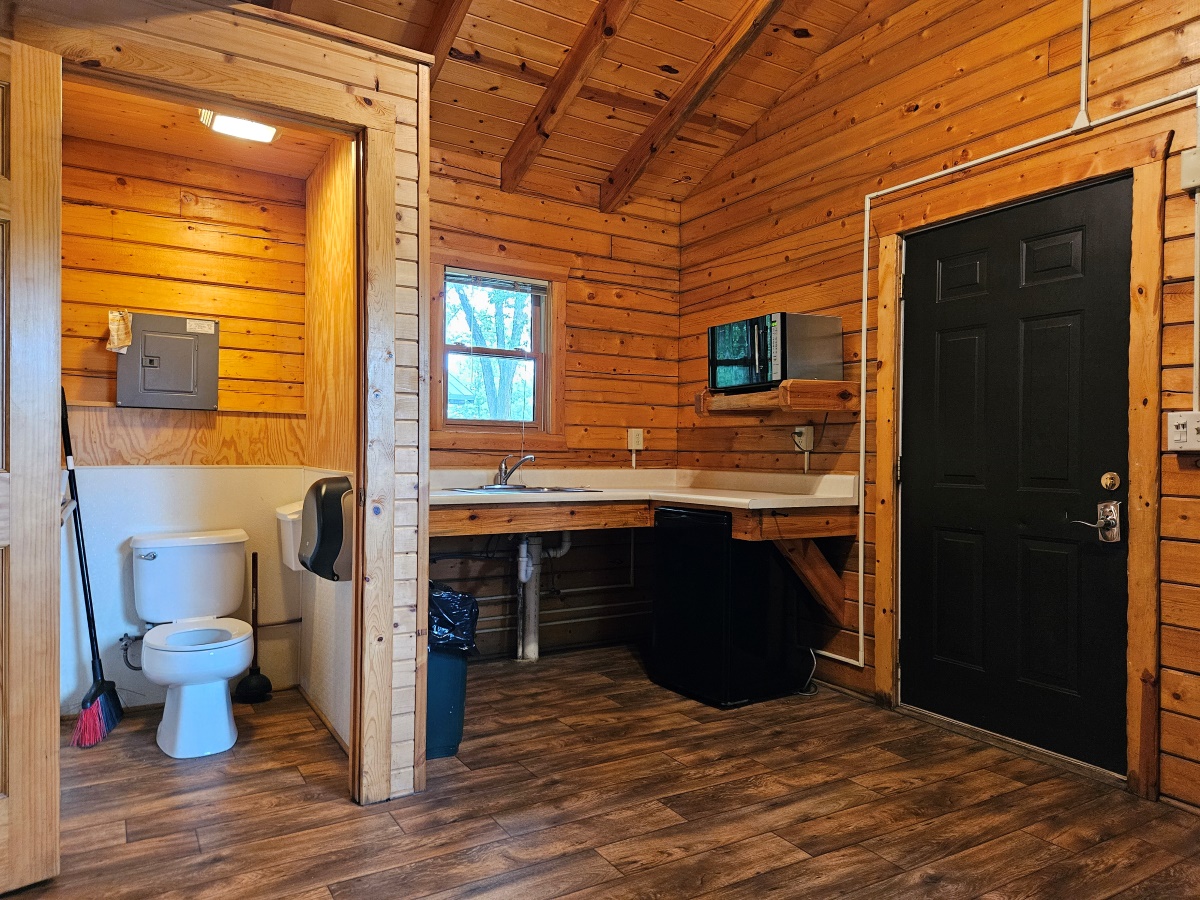 Prairie Rose - Cabin interior showing enclosed private toilet, kitchen area & exterior door