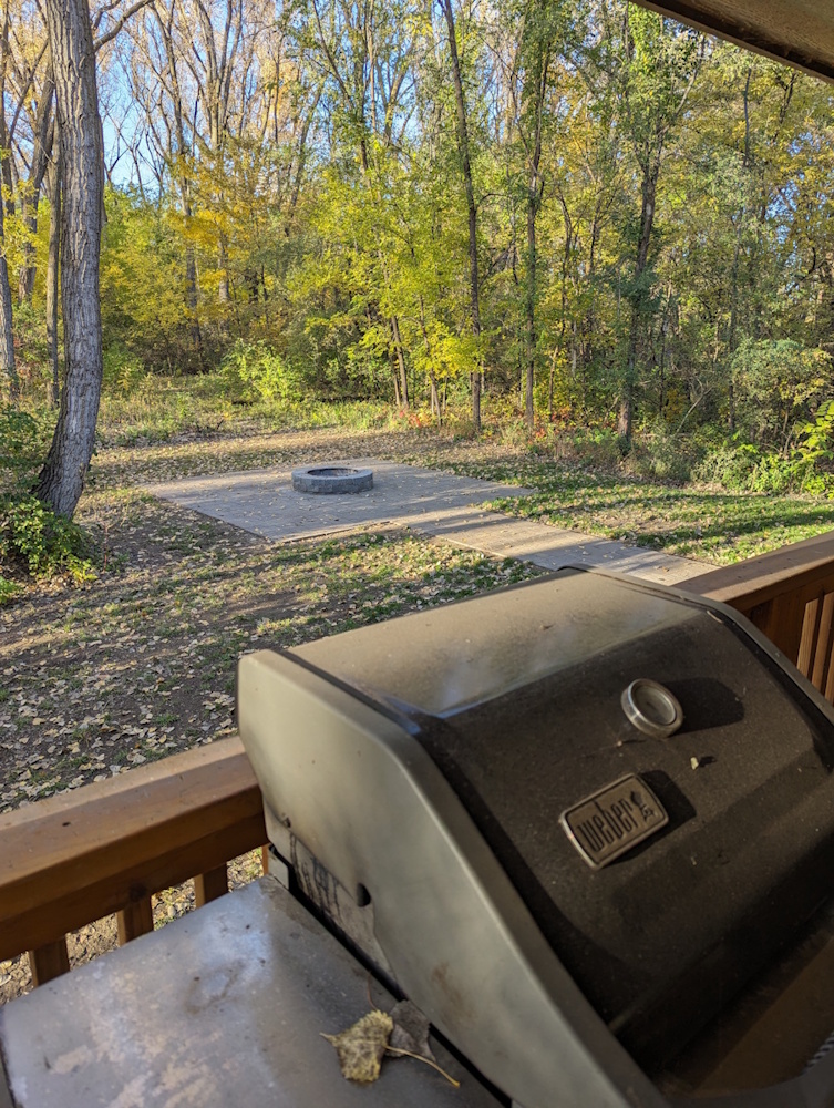 Grill on deck looking out over personal fire pit patio 