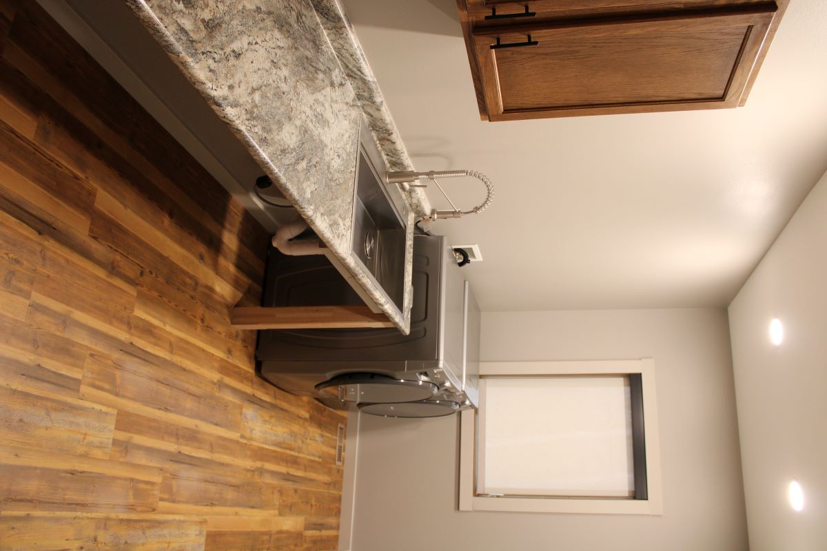 Laundry room with a washer, dryer, cabinets, sink, and countertop