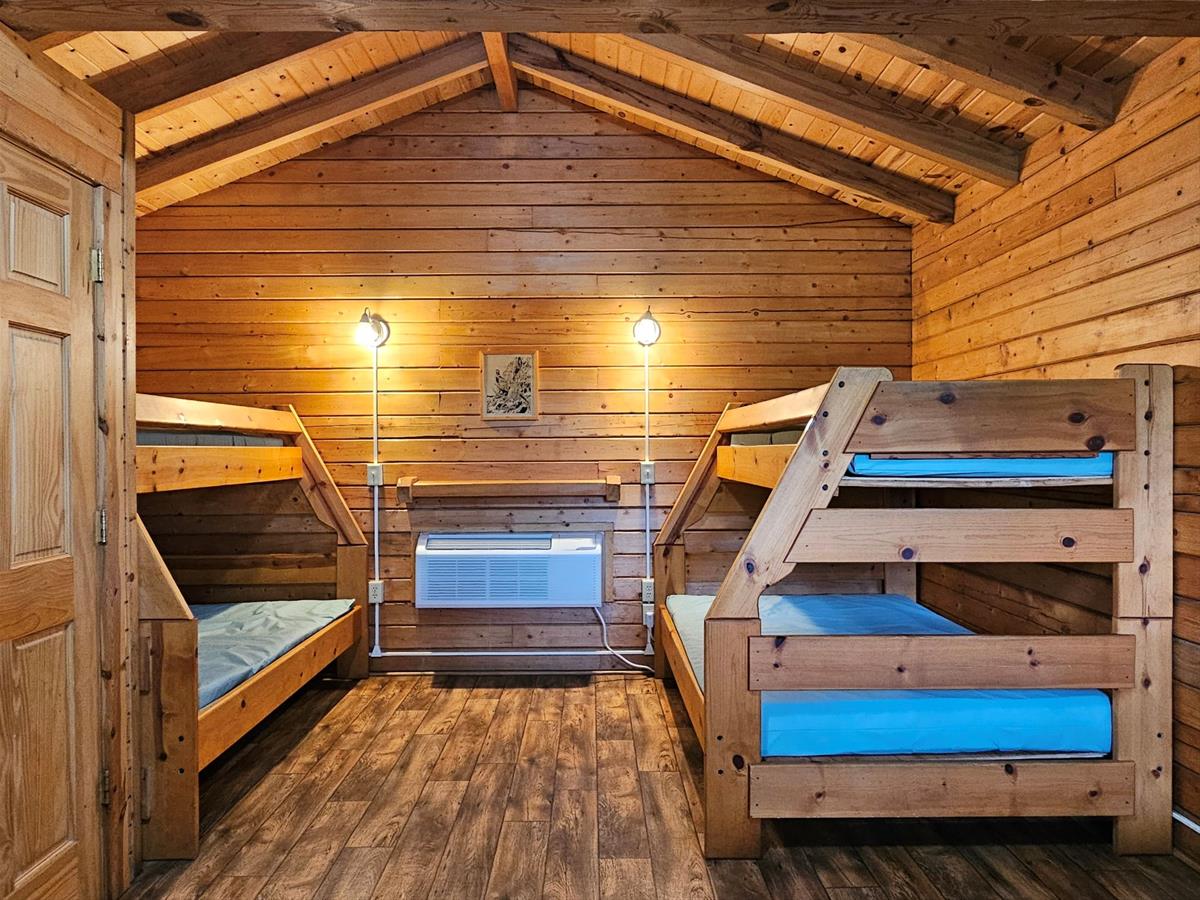 Bluestem - Cabin interior with two twin-over-full wooden bunk beds