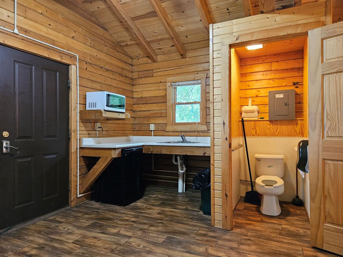 Bluestem - Cabin interior showing enclosed private toilet, kitchen area & exterior door