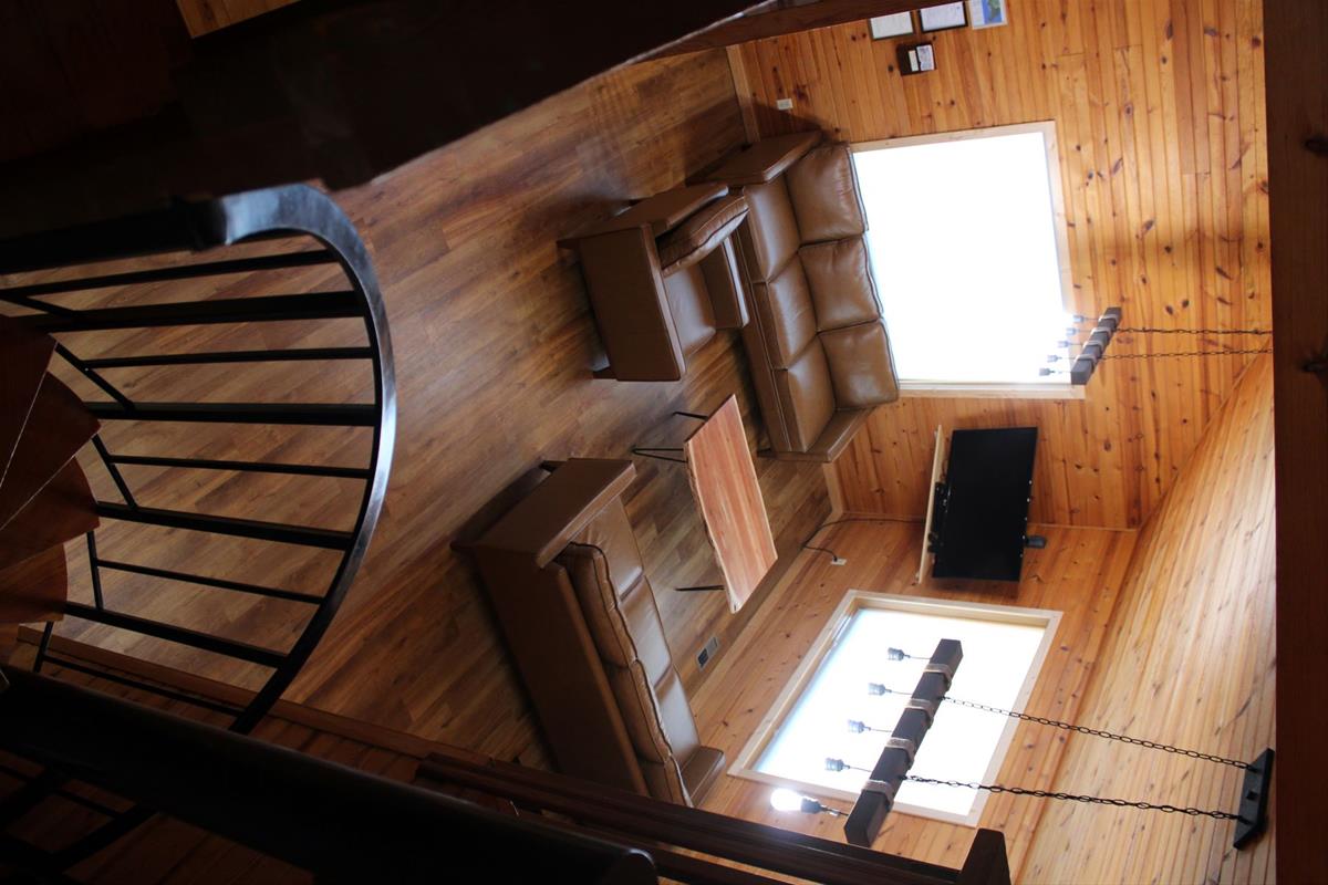 Living room area from the second floor with a winding staircase leading to the main level 